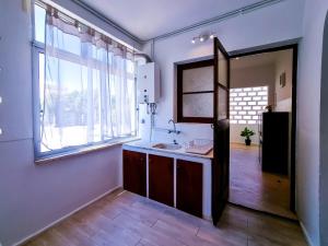 een keuken met een wastafel en een groot raam bij FLH Loulé Balcony Spacious Apartment in Loulé