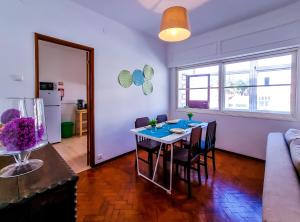 een woonkamer met een tafel en stoelen en een bank bij FLH Loulé Balcony Spacious Apartment in Loulé