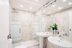 bagno bianco con lavandino e doccia di Luxury & Design Apartment Madrid Center 3BRM 3BTHR a Madrid