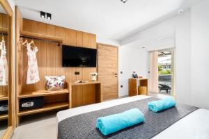 a bedroom with a bed with two blue pillows at Emily's Luxury Suites in Pefkochori