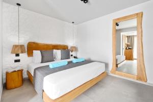 a bedroom with a large bed and a mirror at Emily's Luxury Suites in Pefkochori