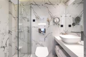 a bathroom with a shower and a toilet and a sink at Emily's Luxury Suites in Pefkochori
