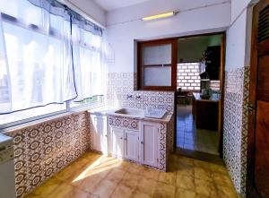 cocina con fregadero y ventana en FLH Loulé Balcony Family Apartment, en Loulé