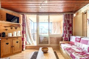 a living room with a couch and a window at Appartement chaleureux à Val Thorens, 36m², à 40m des pistes in Val Thorens