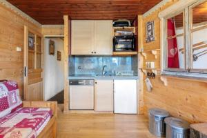 a kitchen with white cabinets and a sink in a tiny house at Appartement chaleureux à Val Thorens, 36m², à 40m des pistes in Val Thorens