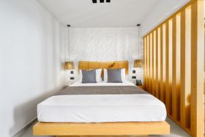 a bedroom with a large bed with a wooden headboard at Emily's Luxury Suites in Pefkochori