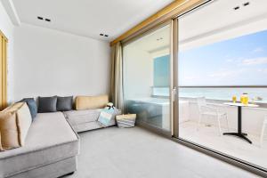 a living room with a couch and a view of the ocean at Emily's Luxury Suites in Pefkochori