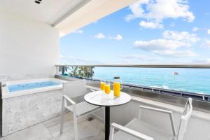 a balcony with a table and chairs and a bathtub at Emily's Luxury Suites in Pefkochori