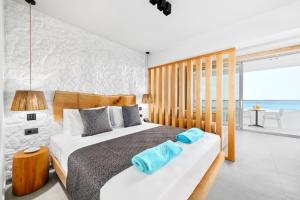 a bedroom with a bed with blue towels on it at Emily's Luxury Suites in Pefkochori