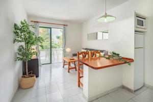 a kitchen and dining room with a table and a plant at Lanzahost Casa Cala in Costa Teguise