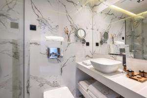 a white bathroom with a sink and a shower at Emily's Luxury Suites in Pefkochori