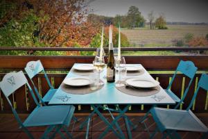 einen blauen Tisch mit Stühlen und eine Flasche Wein in der Unterkunft MaNaLa "120 m2" in Algolsheim