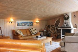 a living room with leather furniture and a fireplace at Hotel Dimon in Stora Mork