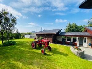 a red tractor parked in a yard in front of a house at Hotel Dimon in Stora Mork