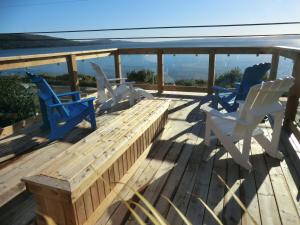 una terraza con 2 sillas y un banco de madera en Admiral Digby Inn Restaurant and Cottages, en Digby