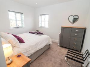 1 dormitorio con 1 cama y vestidor con espejo en The Old Bakery, Apartment 5, en Shipston on Stour