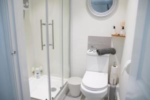 a white bathroom with a toilet and a shower at The Cottage in Bristol
