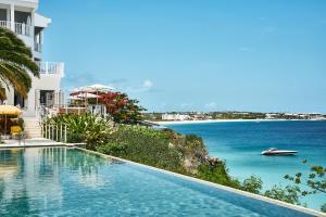 a swimming pool with a view of the ocean at Malliouhana Resort Anguilla in Meads Bay