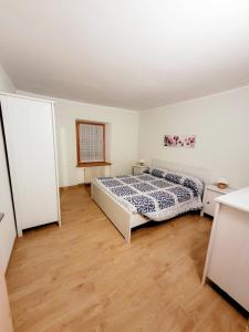 um quarto com uma cama e piso em madeira em Appartamento Rosina, per 4/6 persone. In centro em Coredo