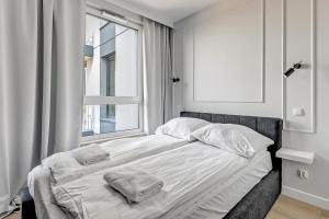 a bedroom with a bed with two towels on it at Chlebova Deluxe 2 Gdańsk by Grand Apartments in Gdańsk