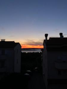 - une vue sur le coucher de soleil depuis deux bâtiments dans l'établissement Apartment NEEA Stinjan -free parking, à Pula