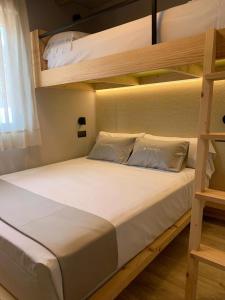 1 dormitorio con litera con sábanas y almohadas blancas en La Marina Resort, en La Marina