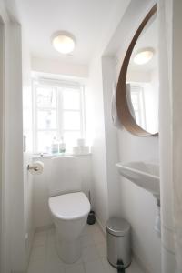 a white bathroom with a toilet and a sink at LBS 1 to 4 - Carolinas Apartments in Copenhagen