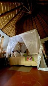 Bett mit weißem Baldachin in einem Zimmer in der Unterkunft Kibale Guest Cottages in Fort Portal
