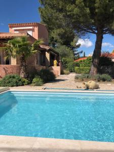 una grande piscina blu di fronte a una casa di Villa les 3 lumières 8-10 personnes, Clim, piscine à proximité des plages a La Ciotat