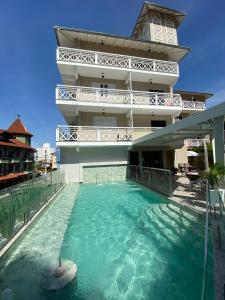 a hotel with a swimming pool in front of a building at Hotel Recanto Do Rouxinol in Piratuba