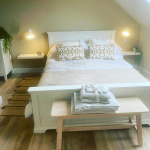 a bedroom with a large white bed with towels on a table at Nettleford in Kelsall