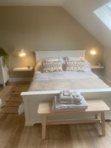 Un dormitorio con una gran cama blanca y una mesa en Nettleford, en Kelsall