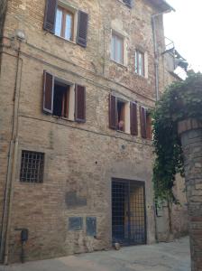 an old brick building with open windows and a door at Pinturicchio, Characteristic and comfortable apartment in the historic center in Perugia