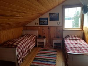 pokój z 2 łóżkami w drewnianym domku w obiekcie Ferienhaus Anders w mieście Terjärv