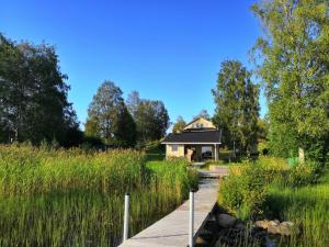 dom w środku pola wysokiej trawy w obiekcie Ferienhaus Anders w mieście Terjärv