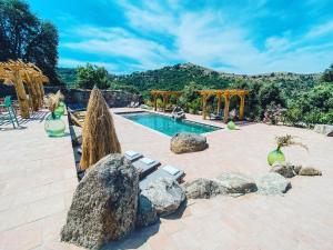 una piscina rodeada de rocas con cenador en Résidence de Luxe 4 étoiles à Pietralba, 4 logements piscine chauffée BALAGNE, en Pietralba
