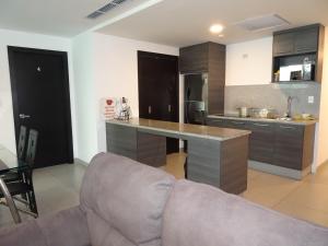 een keuken met een bank en een tafel in een kamer bij 1340 Quo Habitación en Lujoso Departamento a 1 minuto del Aeropuerto in Guayaquil