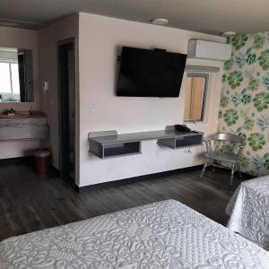 a bedroom with a flat screen tv on a wall at Hotel Kyrios Veracruz in Veracruz +35 photos
