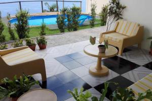 un patio con sillas, una mesa y una piscina en Room Seaview, en Câmara de Lobos