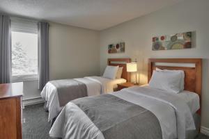 a hotel room with two beds and a window at Blue Mountain Resort Home Collection in Blue Mountains