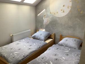 2 camas individuais num quarto com um mural lunar em Apartament Villa Mikołajki Ptasia 16 em Mikolajki