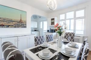 a kitchen with a dining room table with a vase of flowers at The Woodgrange by Sorted Stay in Southend-on-Sea