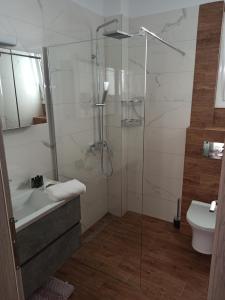 y baño con ducha, bañera y lavamanos. en Cyclops Luxury Apartments en Igoumenitsa