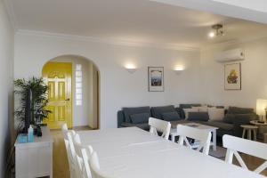 uma sala de estar com uma mesa branca e um sofá em Hopstays Vilamoura Aldeia do Golfe - House C3 em Vilamoura