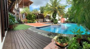 a swimming pool in a yard with a wooden deck at Guesthouse Mata da Praia in Vitória