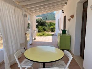 a yellow table and chairs on a patio with a table and chairs at casa filippa in Sassari