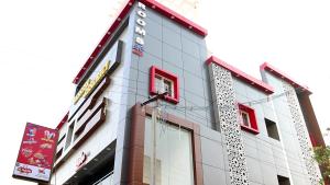 a tall white building with red windows at Venster Residency in Chennai