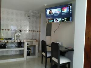 a kitchen with a table and a tv on the wall at Apartamento oasis del norte in Cali