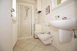 a white bathroom with a sink and a toilet at Sirena Apartments in Lido degli Estensi +64 photos