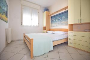 a bedroom with a large bed and a window at Sirena Apartments in Lido degli Estensi